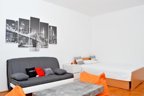 een slaapkamer met een bed en een bank bij Braavos in Šibenik