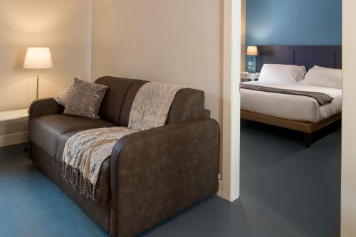 a bedroom with a couch next to a bed at Almarossa in Bologna