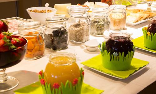 a table topped with jars of food and other foods at Best Western Hotel Metropoli in Genova