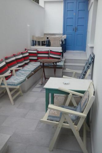 a room with chairs and a table and a blue door at Windmill Naxos in Naxos Chora