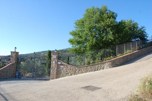 a stone fence with a wrought iron gate at Villa Lucrezia in Reggello