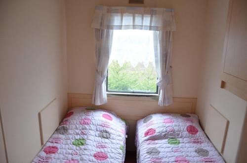 een kleine kamer met een bed en een raam bij Domek nad jeziorem Gaładuś in Sejny