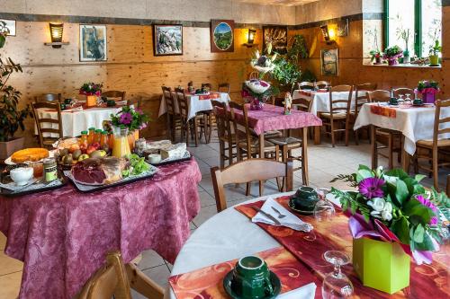 a restaurant with tables and chairs with food on them at Hotel de France in Chaudeyrac