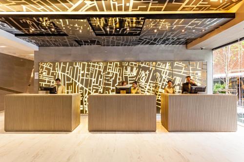 a lobby with people sitting at desks in a building at Best Western Plus Sukhumvit 1 in Bangkok