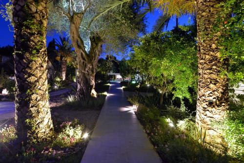 a sidewalk with trees and lights in a park at TRYP by Wyndham Corfu Dassia in Dassia