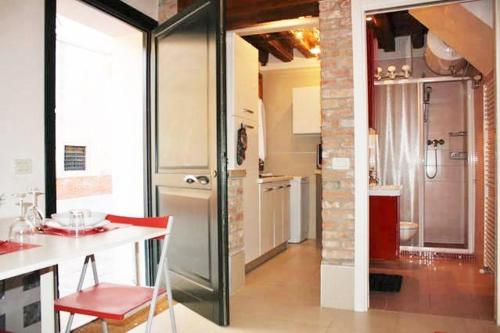 ヴェネツィアにあるApartment 3028のキッチン(カウンター、赤い椅子付)