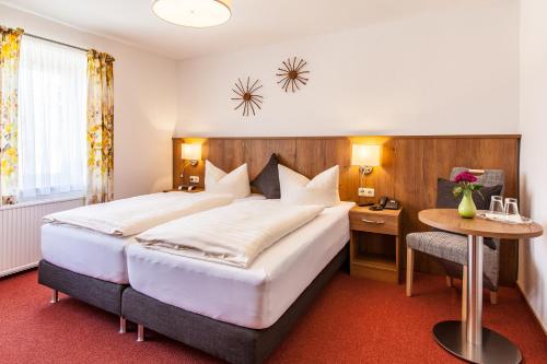 a hotel room with a large bed and a desk at Wanderhotel Sonnebergbaude in Waltersdorf