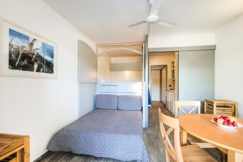 une petite pièce avec un lit et une table dans l'établissement Residence Hyeres Parc - maeva Home, à Hyères