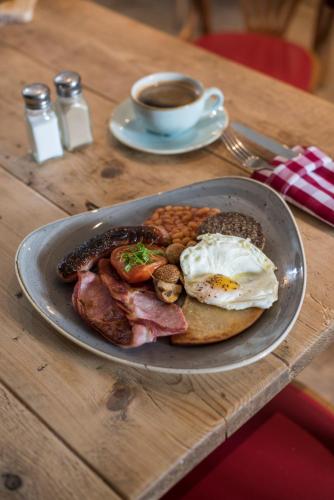 a plate of breakfast food on a table with a cup of coffee at Buccleuch Arms in Saint Boswells