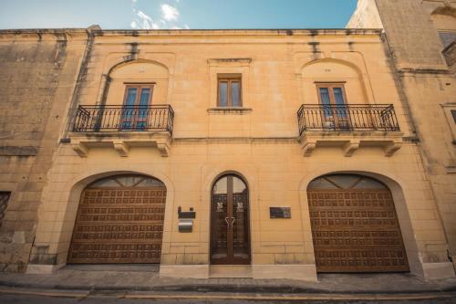 a building with two garage doors and two balconies at IL-Gardjola Bed and Breakfast in Għarb