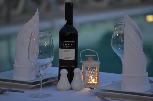 a bottle of wine sitting on a table with two glasses at Konstantina Apartments in Kavos