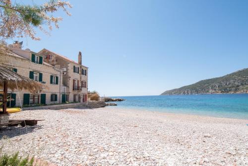 a beach with a building and the ocean at Apartments On the Beach in Komiža