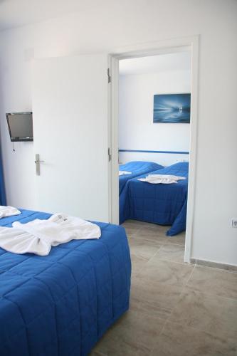 a bedroom with two blue beds and a mirror at Rota Hotel in Dalyan
