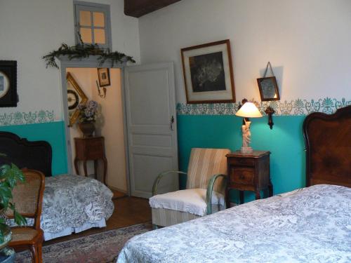 BuxyにあるChambres d'hôtes la Graineterieのベッドルーム1室(ベッド2台、椅子、ランプ付)