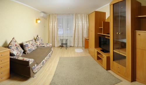 オムスクにあるOmsk Sutki Apartments on Irtyshskaya Naberezhnaya 12のリビングルーム(ソファ、テレビ付)
