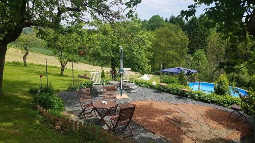 a patio with a table and chairs next to a pool at FerienAppartments Landhaus FühlDichWohl in Fehring
