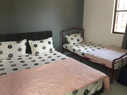 deux lits côte à côte dans une pièce dans l'établissement Lot 1281, Villa D'Amour, à Malacca