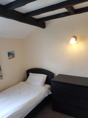 a bedroom with a bed and a dresser and a lamp at Holly Cottage in Burgh le Marsh