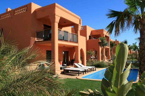 a large house with a swimming pool in front of it at Amendoeira Golf Resort in Armação de Pêra