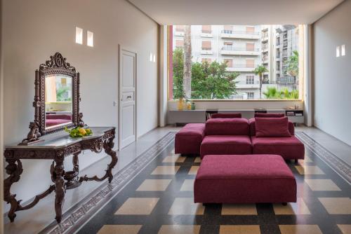 a living room with red couches and a mirror at Giardini Mon Plaisir in Trapani