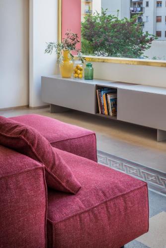 a living room with a red couch and a table at Giardini Mon Plaisir in Trapani