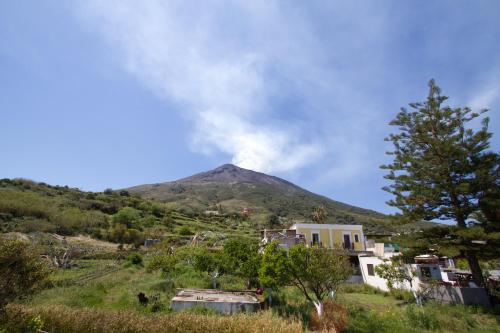 a mountain in the distance with a house in the foreground at La Locanda del Barbablù in Stromboli