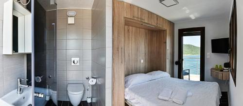アムリアニにあるPension Limaniのバスルーム(ベッド1台付)、バスルーム(シャワー付)が備わります。