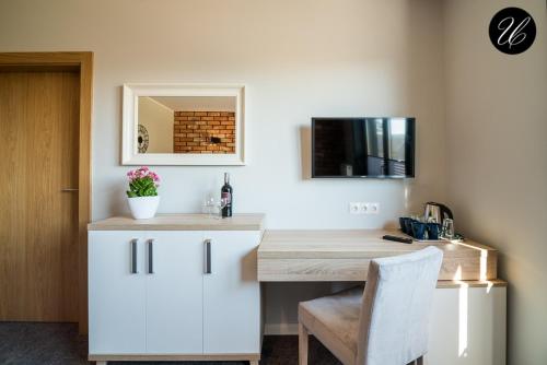 a kitchen with a white desk and a white chair at U przyjaciol - Debki in Dębki