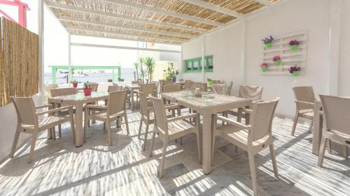 une salle à manger avec des tables et des chaises en bois dans l'établissement Hotel Sphinx, à Naxos Chora