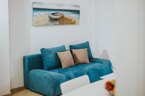 a blue couch in a living room with a painting at Stephanie Studios in Larnaca