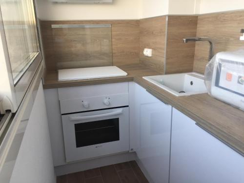 a small kitchen with a sink and a stove at Studio Bord de Mer et VUE sur MER WIFI OFFERT in La Seyne-sur-Mer
