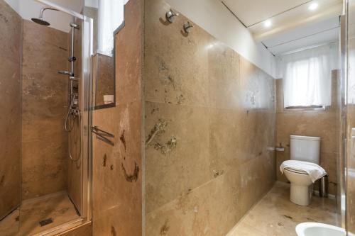 ein Bad mit einer Dusche und einem WC in der Unterkunft Roommo San Iacopino in Florenz