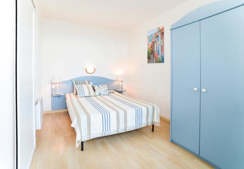 コリウールにあるResidence Les Balcons de Collioure - maeva Homeの白いベッドルーム(ストライプのベッドカバー付)