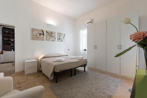 Habitación blanca con cama y mesa en Roommo San Iacopino, en Florencia