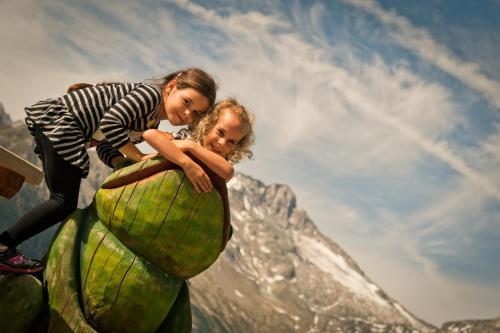 a young girl is standing on top of an elephant at Hotel Mühlenerhof in Campo Tures