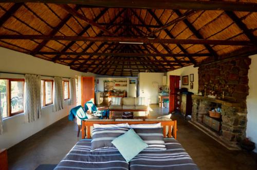 a living room with a bed and a stone wall at Swartkop Cottage in Winterton