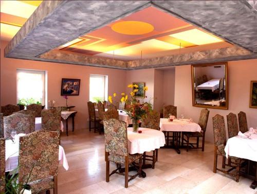 a dining room with tables and chairs and a mirror at Aux Deux Clefs in Petersbach