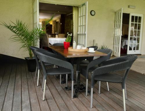 a wooden table and chairs on a patio at Tumbling Weir Hotel in Ottery Saint Mary