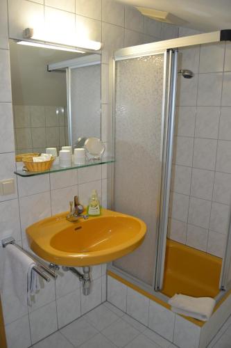 a bathroom with a yellow sink and a shower at Gästehaus Elisabeth in Radstadt