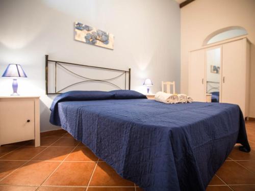 a bedroom with a blue bed with two towels on it at Appartamento gli archi a 100 metri dalla spiaggia in Castellammare del Golfo