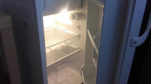 an empty refrigerator with its door open with the light on at Apartment Lisinski S in Zagreb