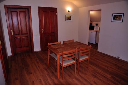 a dining room with a table and chairs and a kitchen at Modrzewiowe Wzgorze in Promno