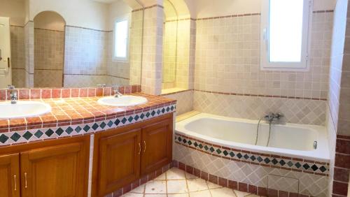 une salle de bain avec deux lavabos et une baignoire dans l'établissement Luxueuse Villa Récente à Saint Raphaël de Plain Pied, à Saint-Raphaël