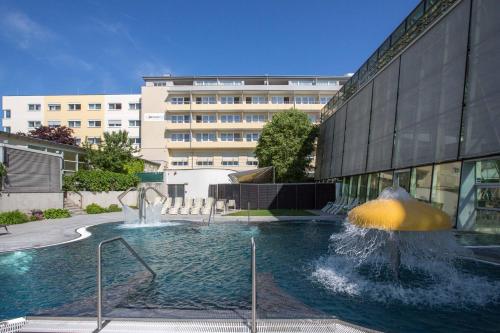 a building with a fountain in front of a building at Badener Hof in Baden