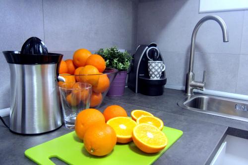 トッサ・デ・マールにあるTossa Unique Moments Apartmentの台所用カウンターの緑のまな板に盛られたオレンジ