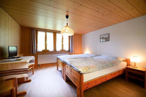 ein Schlafzimmer mit einem großen Bett und einem TV. in der Unterkunft Landgasthof Tännler in Innertkirchen