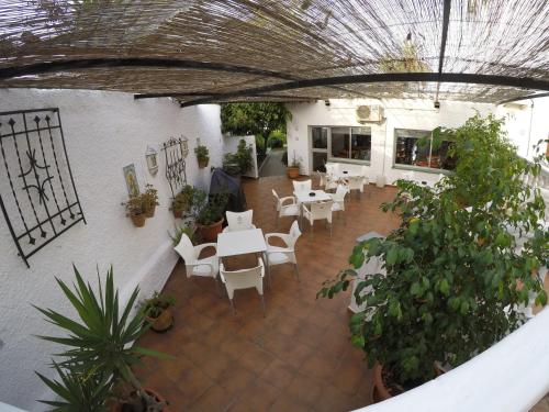 a restaurant with white tables and chairs and plants at Hotel Complejo Los Rosales in Torremolinos