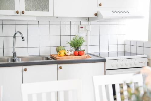 un mostrador de cocina con frutas y verduras en una tabla de cortar en Halmstad Hotell & Vandrarhem Kaptenshamn en Halmstad