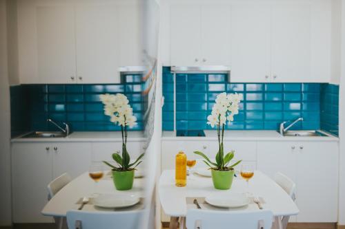 a kitchen with two tables with glasses of wine and flowers at Stephanie Studios in Larnaka