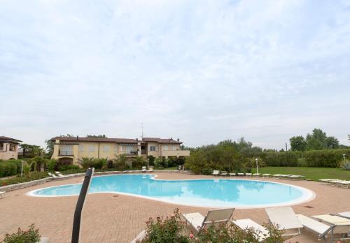 a large swimming pool with lounge chairs around it at Villetta Nico Sirmione in Sirmione